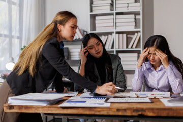 Stressed annoyed office employee manager having headache migraine at business meeting with colleagues about business problem they have to solve. Stress at work or migraine concept.
