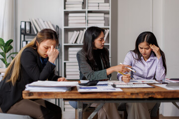 Stressed annoyed office employee manager having headache migraine at business meeting with colleagues about business problem they have to solve. Stress at work or migraine concept.
