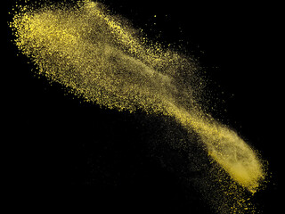 Yellow dust explosion on black background, studio shot