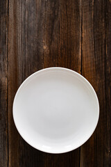 Empty white plate on wooden rustic table