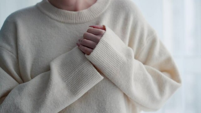 A girl in white coffee holds her heart with her hand.
A young girl has heart pain.
A woman has severe pain in her heart.
A woman has a heart attack and holds her hand to her heart