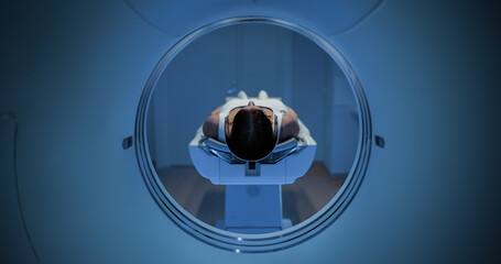 In the Medical Laboratory, Anonymous Female Patient Lying on a CT or MRI Scan Bed Undergoes...