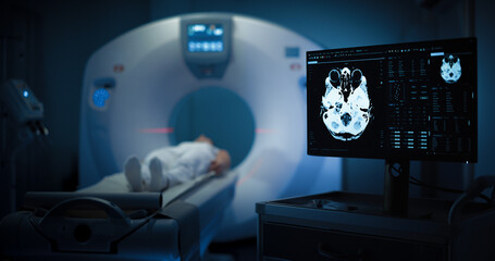 Medium Shot of a Female Patient Lying on a CT or MRI Scan, Bed is Moving Inside the Machine While...