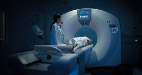 In Medical Laboratory, Radiologist Controls MRI or CT or PET Scan with Patient Undergoing...