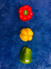 The colored peppers are arranged like the colors of a traffic light on a blue background