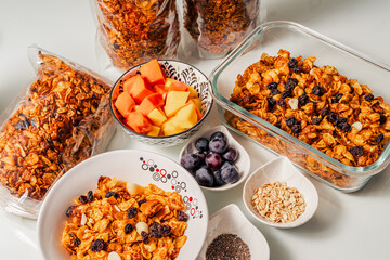photo of healthy breakfast ingredients with handmade granola, chia, oatmeal and fruits mango, papaya and grapes