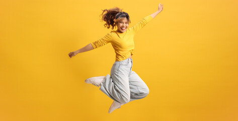 Young cheerful asian female jumping