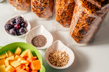 photo of healthy breakfast ingredients with handmade granola, chia, oatmeal and fruits mango, papaya and grapes