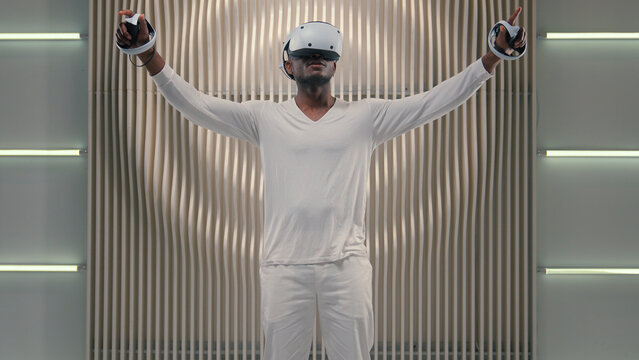 Futurism gaming discovery cyberspace 3d simulation internet video game virtual reality African American man male guy in vr glasses playing in white futuristic room modern technology online metaverse