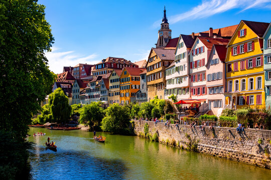 Tuebingen popular university town in southern Germany. &ldquo;Neckarfront&ldquo; with colorful facades, church (Stiftskirche) and poled boats (Stocherkahn) on the River Neckar on a sunny summer day. 