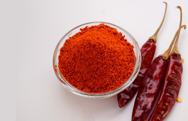 Top View of Red chilly powder in white bowl with red chilly isolated on white background. Selective focus.