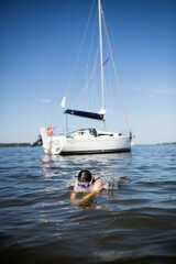 Młoda dziewczyna nurkuje w wodzie, pływa z jachtu i świetnie się bawi © Katarzyna Krociel