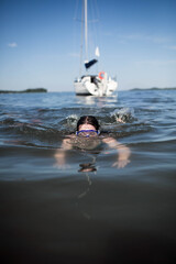 Nastolatka, szczupła dziewczyna skacze do wody z pokładu łodzi, śmieje się i świetnie bawi. © Katarzyna Krociel