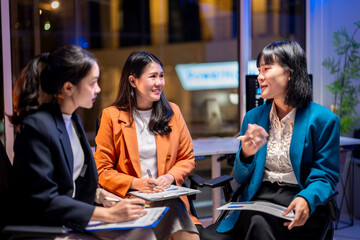 Three women are sitting in a room, smiling and talking to each other