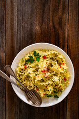 Pasta with garlic, parsley and pepperoncino on wooden table. Boiled mafaldine noodles. Spaghetti aglio olio e peperoncino on wooden background