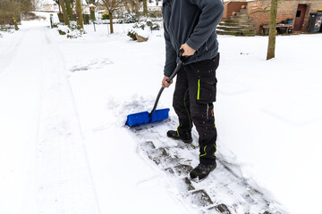 Schnee schieben mit einem bauen Schneeschieber