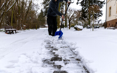 Schnee im Winter auf dem Gehweg räumen