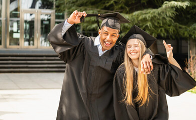 Two multiethnic happy college graduates celebrating graduation day