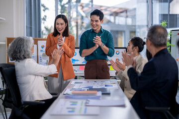 A group of people are clapping in a meeting room