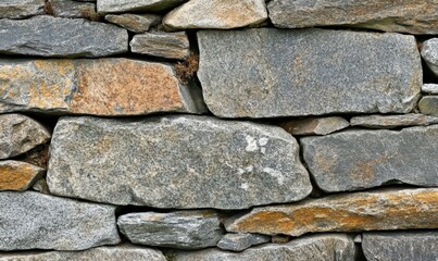 Fototapeta premium Stone wall background. Construction of a vintage old building in nature. Use for wallpapers and textures