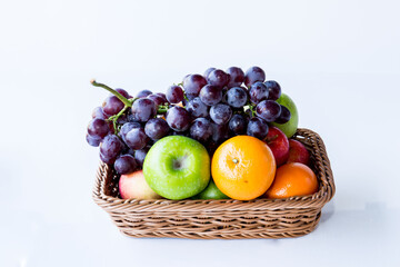 Ripe fruits apples, oranges and grapes in a basket. on white background.concept fruit market and food in supermarket..