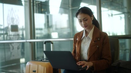 Confident young asian businesswoman working remotely online using laptop at the airport terminal while waiting for her flight, young female browsing the internet for emailing and managing e-business.
- Powered by Adobe