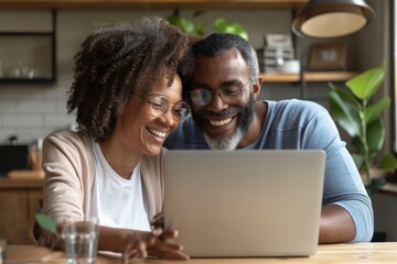 Portrait of a cheerful multicultural couple in their 40s using a laptop together