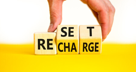 Reset and recharge symbol. Concept words Reset Recharge on beautiful wooden block. Beautiful yellow...