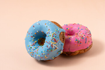 Colorful donuts on pastel pink background.