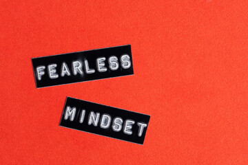 Fearless mindset, tag on red background. Top view. Copy space.