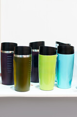 Collection of Colorful Thermal Travel Mugs on Displayed Surface..