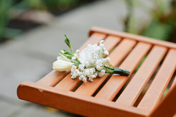 White Floral Arrangement on Wooden Bench in Outdoor Garden Setting..