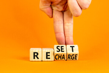 Reset and recharge symbol. Concept words Reset Recharge on beautiful wooden block. Beautiful orange...