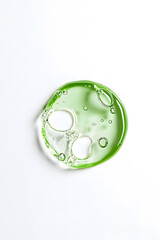 Clear green cosmetic gel serum oil drop isolated on white background. Hyaluronic acid skincare product  top view 