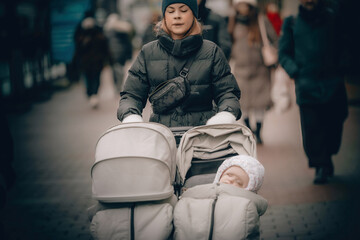 tired mother pushing a stroller with a child