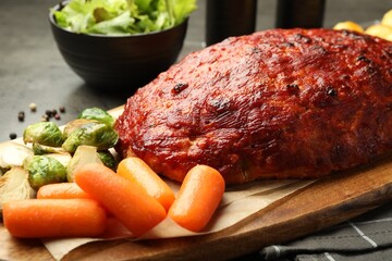 Delicious turkey meatloaf with vegetables on grey table, closeup