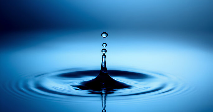 A mesmerizing water drop impacting a tranquil blue surface.
