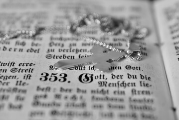 Silberkette mit Kreuz auf altem Psalmbuch