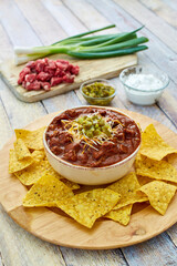 beef chili topped with shredded cheese and jalapeno served with tortilla chips
