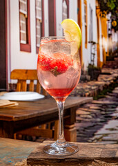 Strawberry cocktail with green apple on a wooden table in a tipical brazilian restaurant
