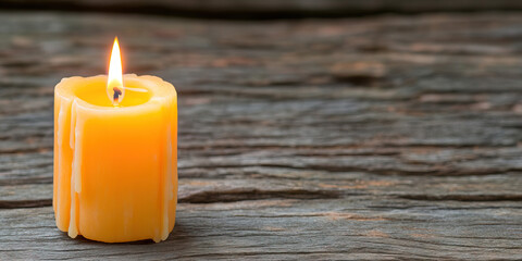 Lit Yellow Candle on Wooden Surface