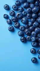 Fresh blueberries create an artistic arrangement on a pastel blue background for a vibrant and refreshing appeal