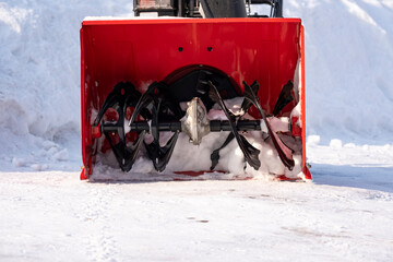 Snowplow against the background of snowdrifts. Portable snowplow in the yard.