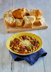 vegetable beef soup topped with parmesan cheese served with bread
