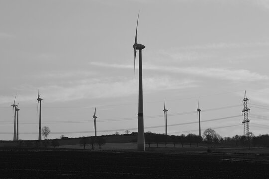 Wind farm with wind turbines or wind mills provide renewable electricity, black and white picture