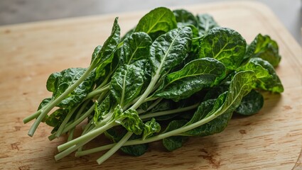 Freshly picked spinach leaves on a wooden cutting board glistening with rain