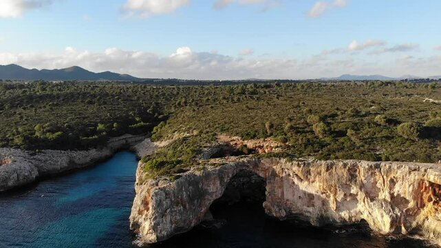 Cala Varques, located on the eastern coast of Mallorca, is a secluded and picturesque cove with crystal-clear turquoise waters and fine white sand. Surrounded by cliffs and lush pine forests