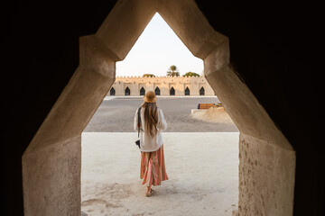 Tourist woman walking into the historic courtyard of the qasr al hosn fort in abu dhabi