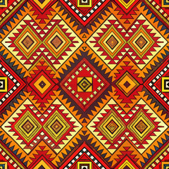 Colorful geometric tribal pattern with intricate symmetrical shapes in warm red, orange, and yellow tones. Traditional ethnic textile design for backgrounds