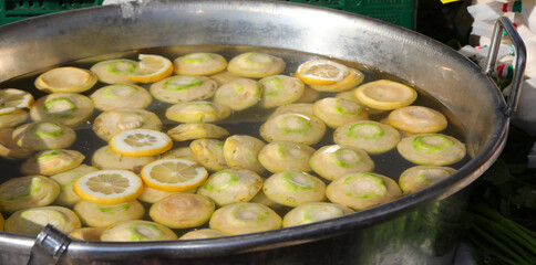 cut artichoke bottoms soaking in a tub of lemon water at the market